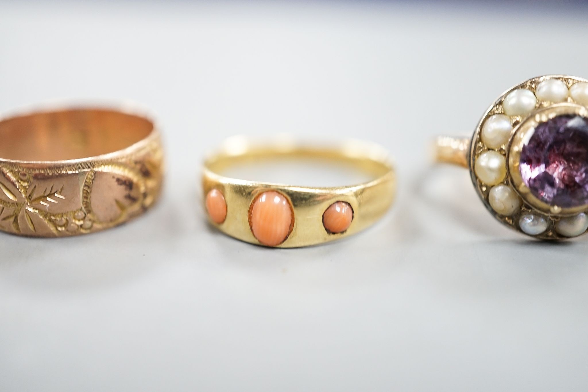 An early 20th century 18ct gold and gypsy set three stone coral ring, size P/Q, a similar sapphire and diamond set triple cluster ring, 5.5 grams, two similar 9ct gold rings, 7.7 grams and a yellow meta, foil backed amet